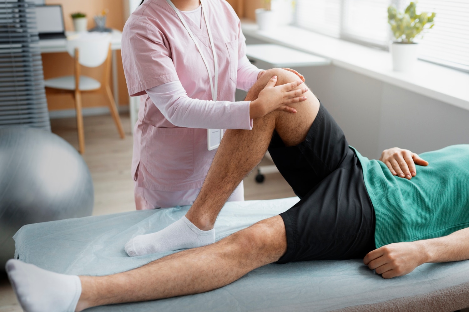 Physical therapist holding a patient's bent knee during a joint mobilization