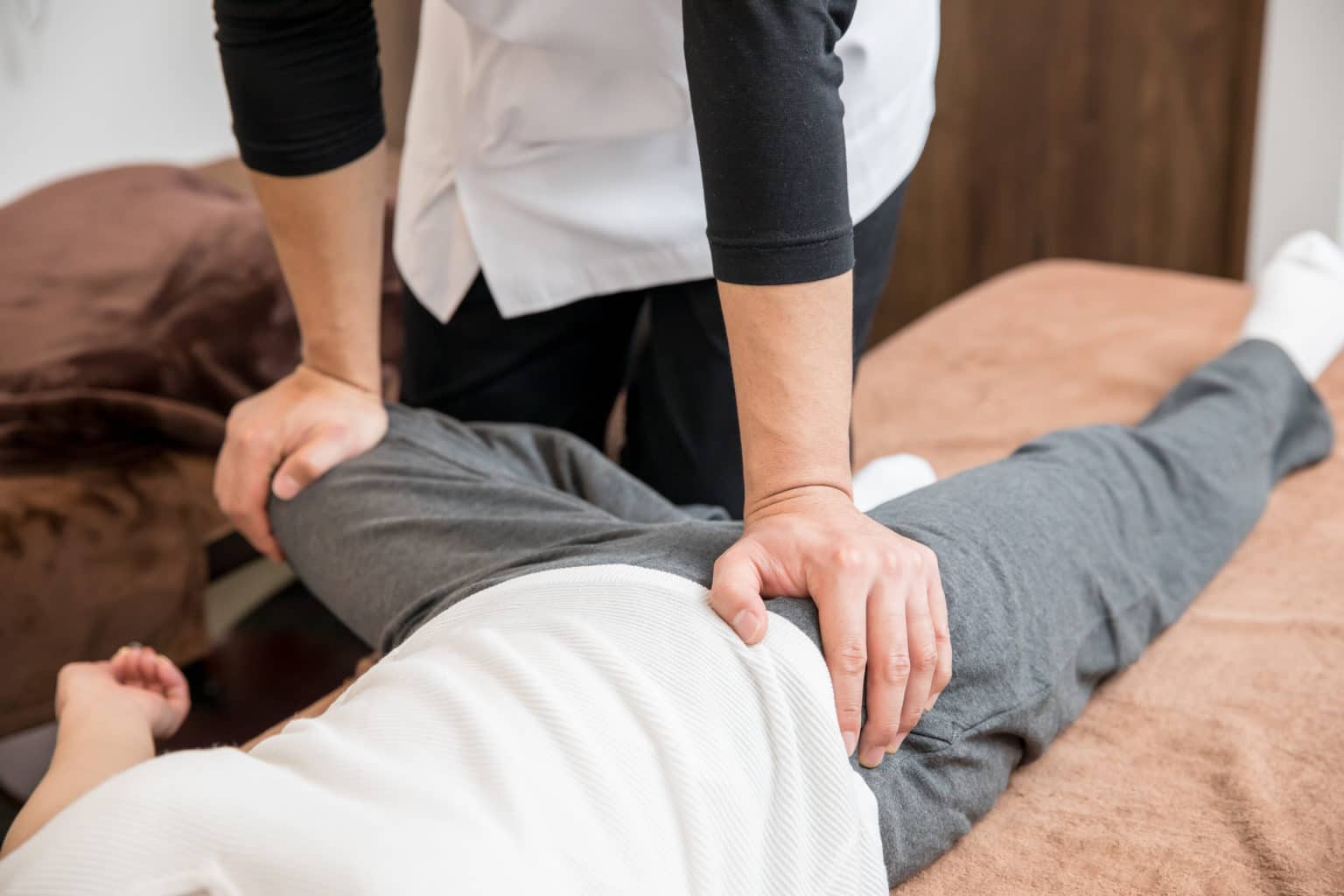 Physical therapist performing a FABER test to assess SI joint and hip pain