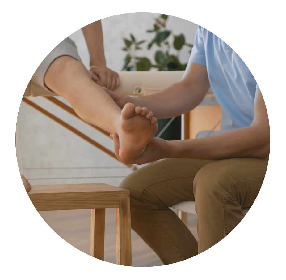 Physical therapist holding a patient's bare foot to assess the ankle