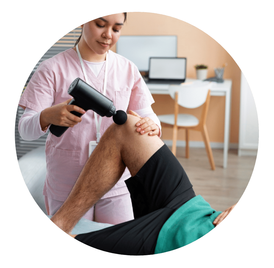 Physical therapist using a percussion massage gun on a patient's knee