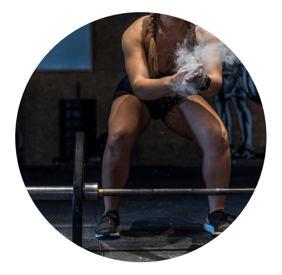 Woman chalking her hands before lifting a loaded barbell
