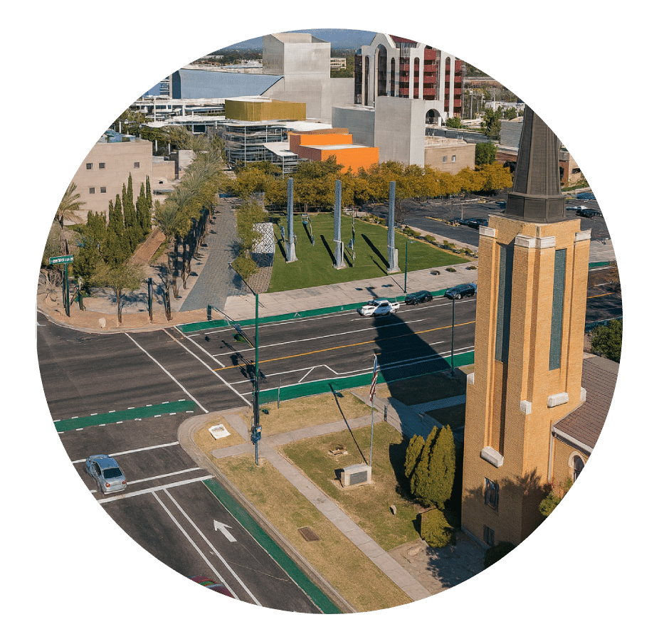 Aerial view of a downtown intersection beside a brick church bell tower