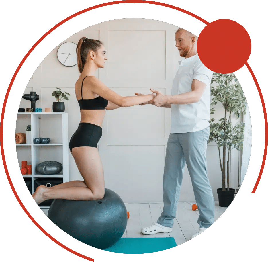 Physical therapist holding a patient's hands as she kneels on a stability ball