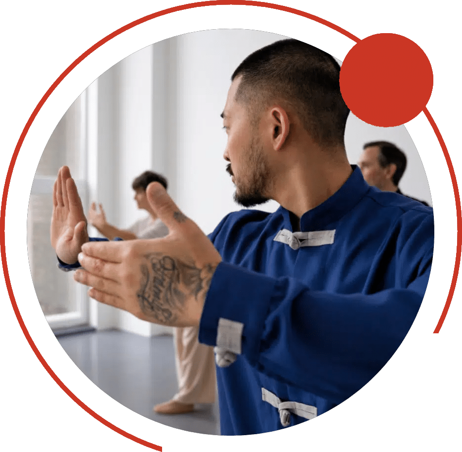 Man in a martial arts uniform practicing a slow hand form in class