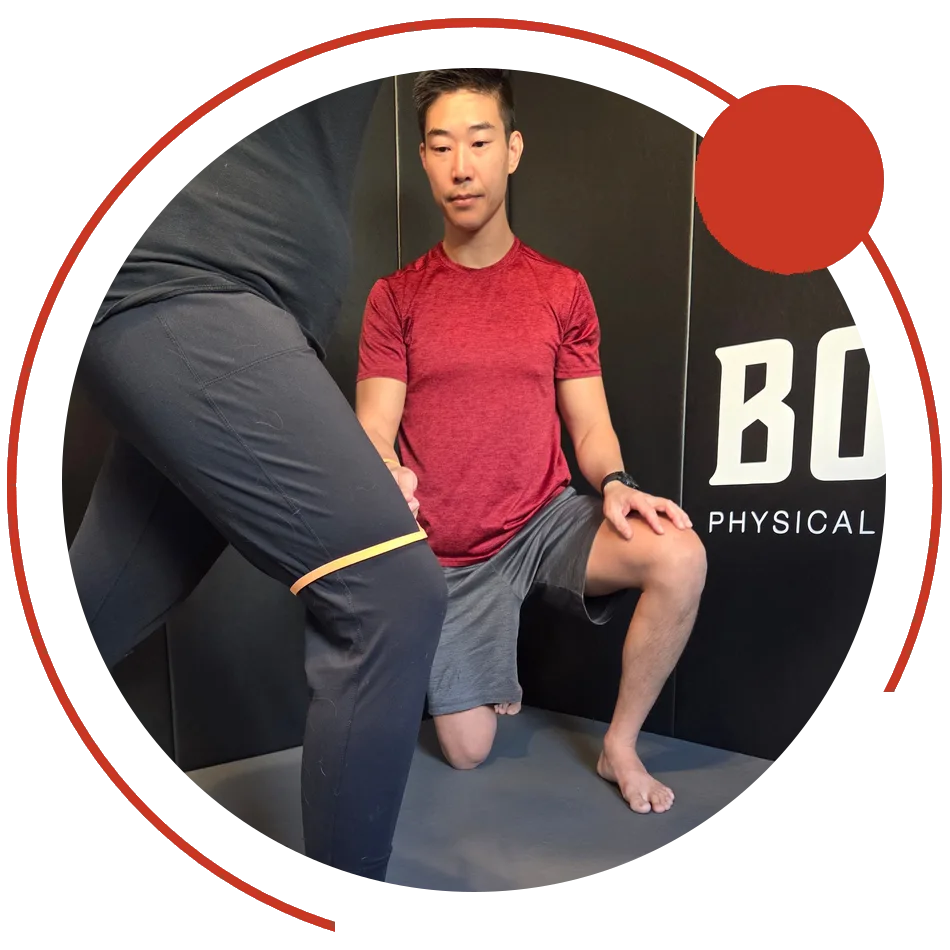Dr. Phil Yoon working on a client's knee control with a band