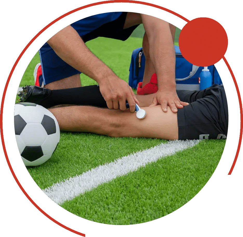 Physical therapist examining a soccer player's injured knee on the field