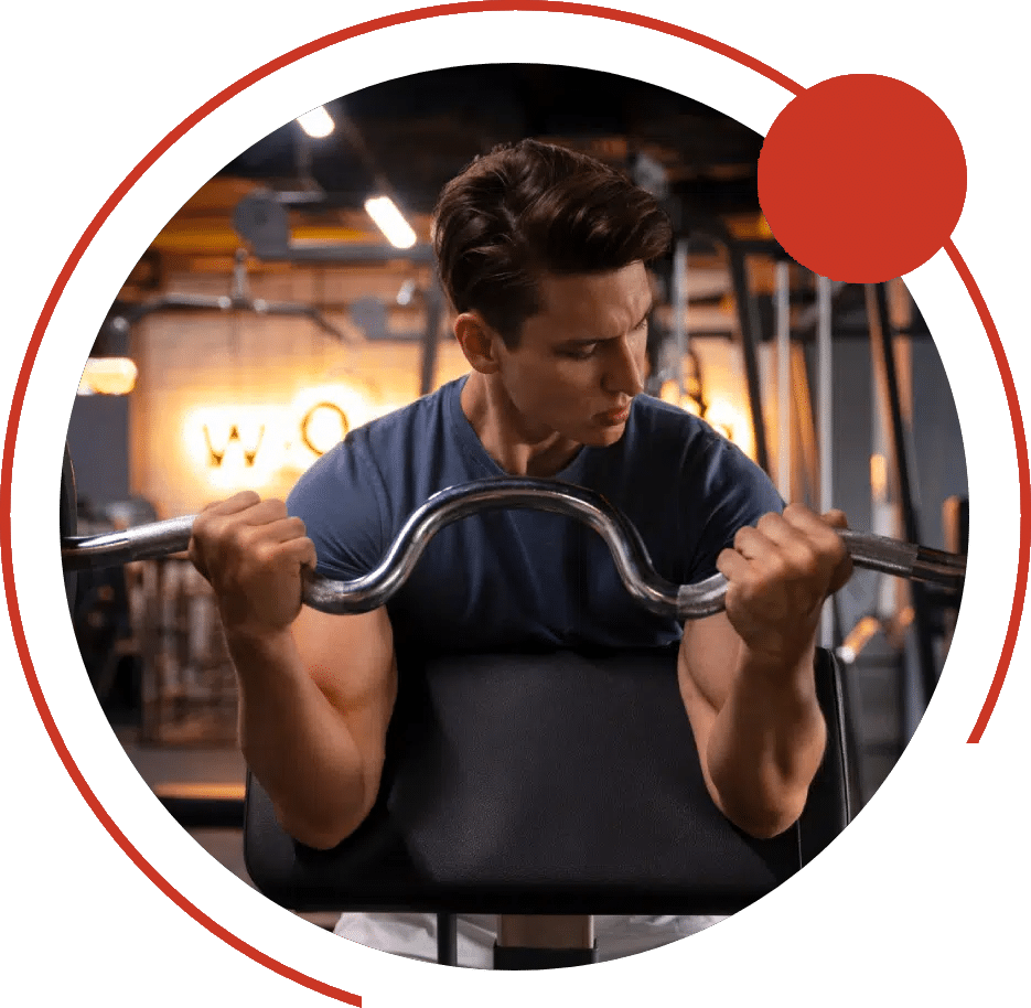 Man doing curls with an EZ bar on a preacher bench in a gym